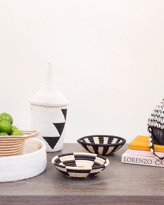 Decorative items including striped bowls, a candle, and books on a wooden surface.