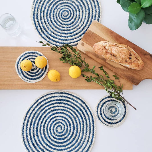 Blue and white spiral coasters on a wooden cutting board with lemons and bread.
