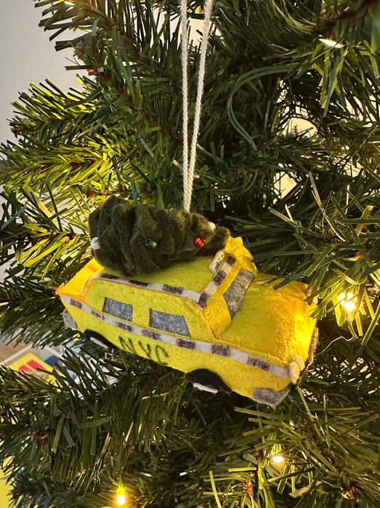 Yellow ambulance plush toy hanging on a Christmas tree