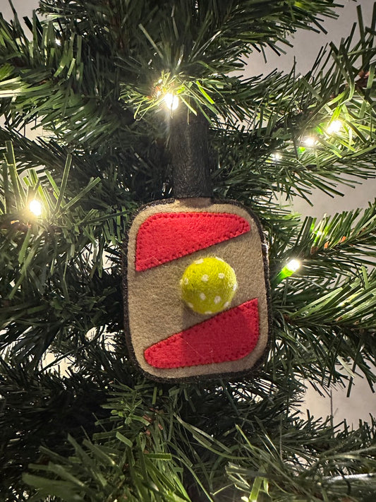 Decorative ornament shaped like a square with a yellow circle on a Christmas tree.