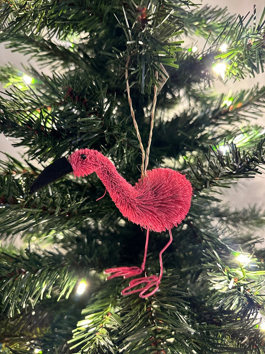 Pink flamingo ornament hanging on a Christmas tree