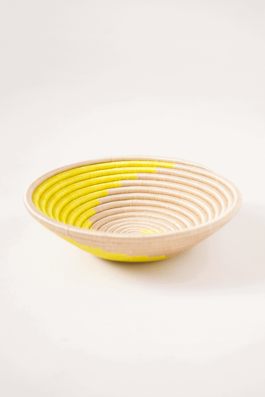 Woven bowl with yellow interior on a white background
