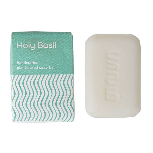 Handcrafted plant-based soap bar with packaging labeled 'Holy Basil' on a white background