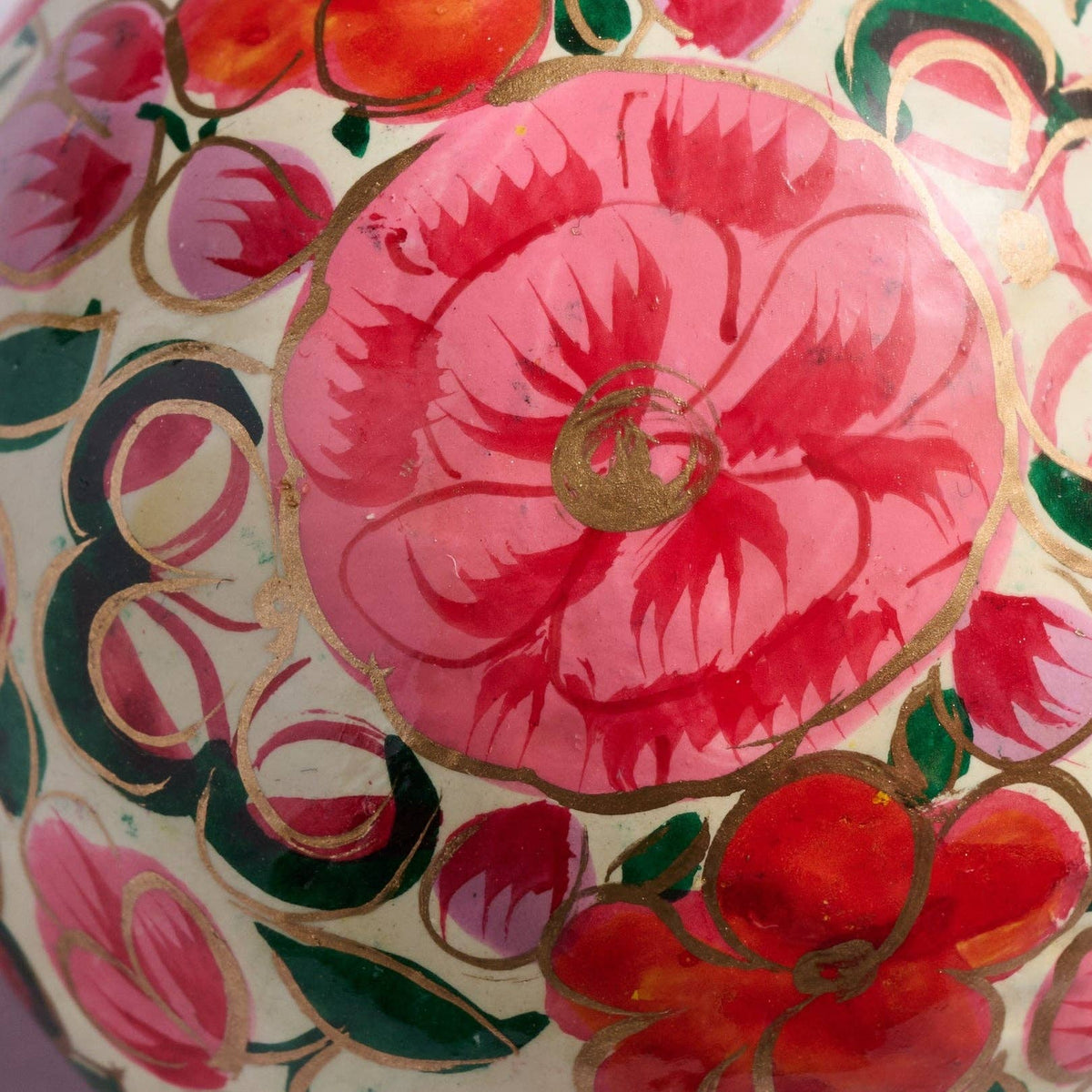 Decorative item with pink floral design on a gold background