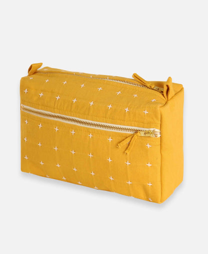 Yellow pouch with white star pattern and gold zipper on a light gray background