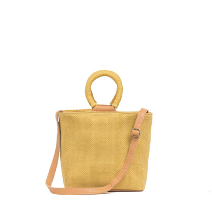 Yellow woven handbag with a strap on a white background