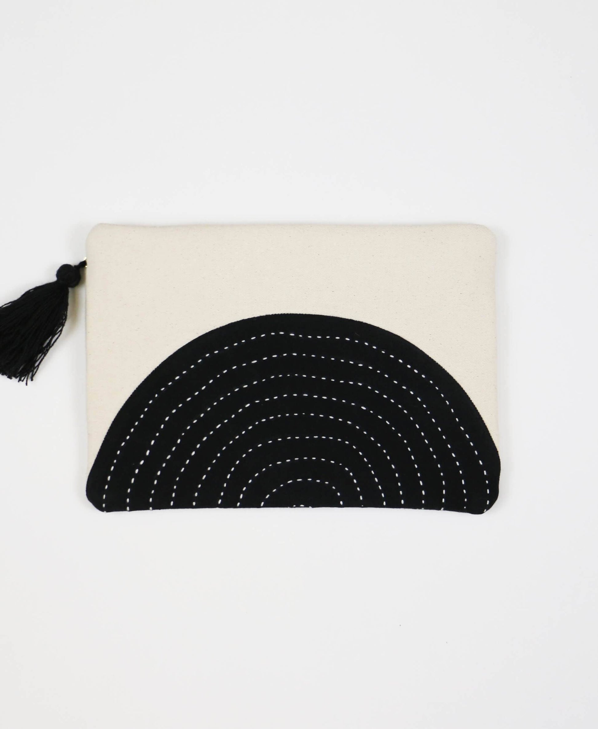 Beige pouch with black circular design and tassel on a white background