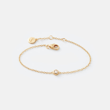 Gold bracelet with a clasp on a light gray background