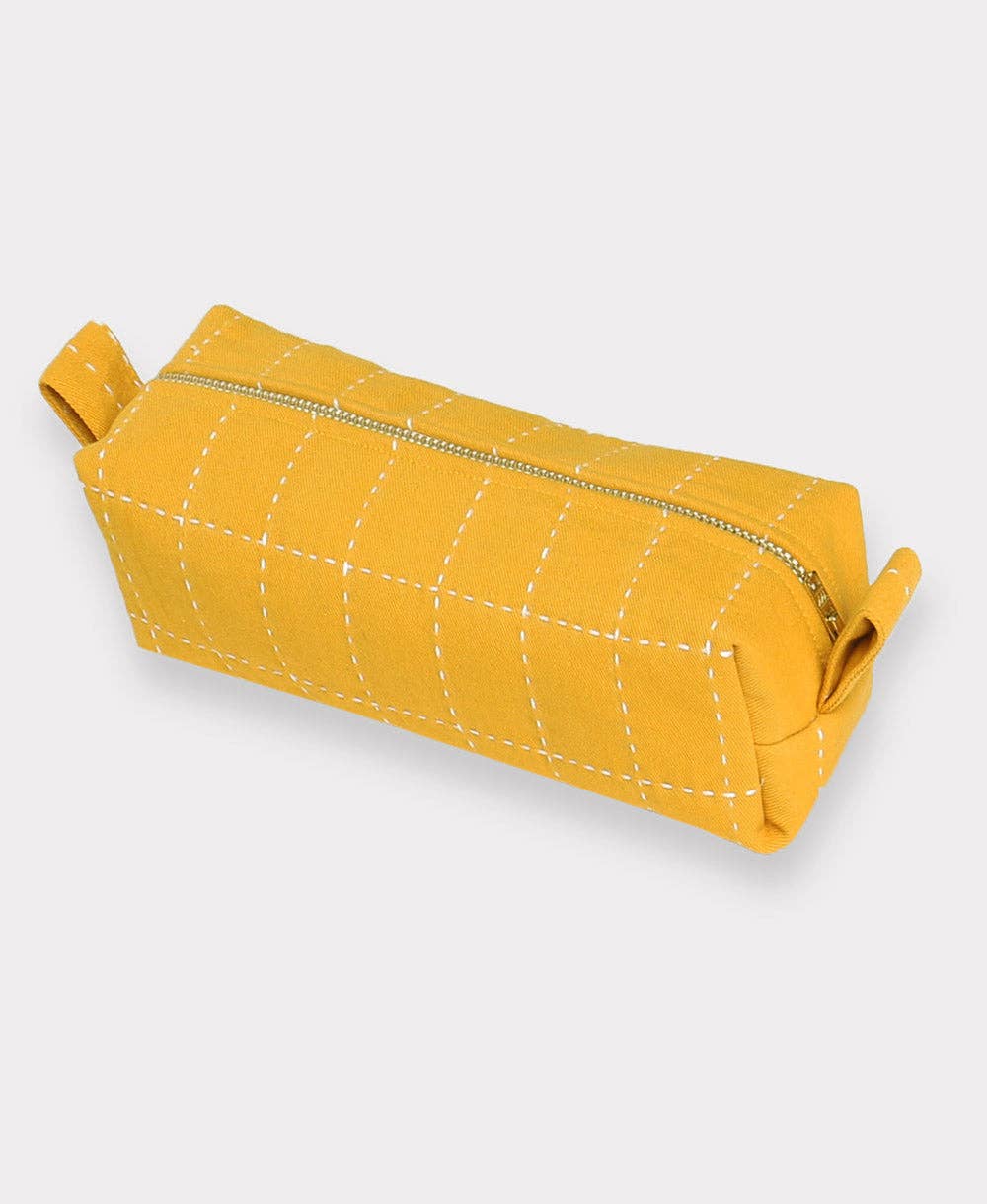 Yellow quilted pouch with a zipper on a light gray background
