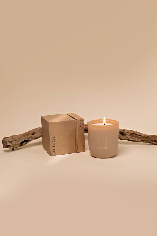 Beige candle with a matching box on a beige background