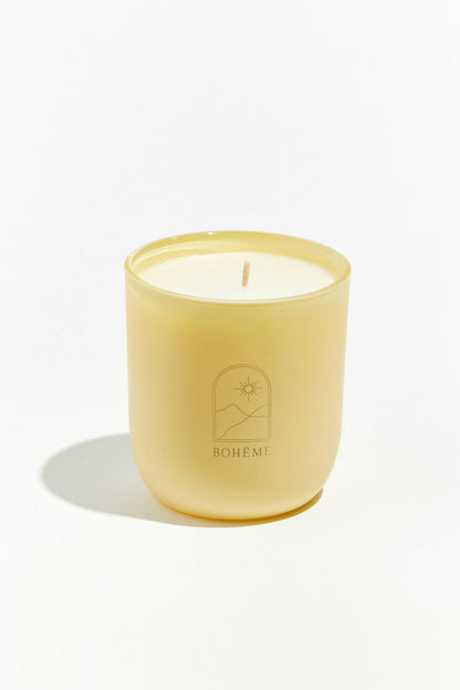 Yellow candle with a visible brand logo on a white background