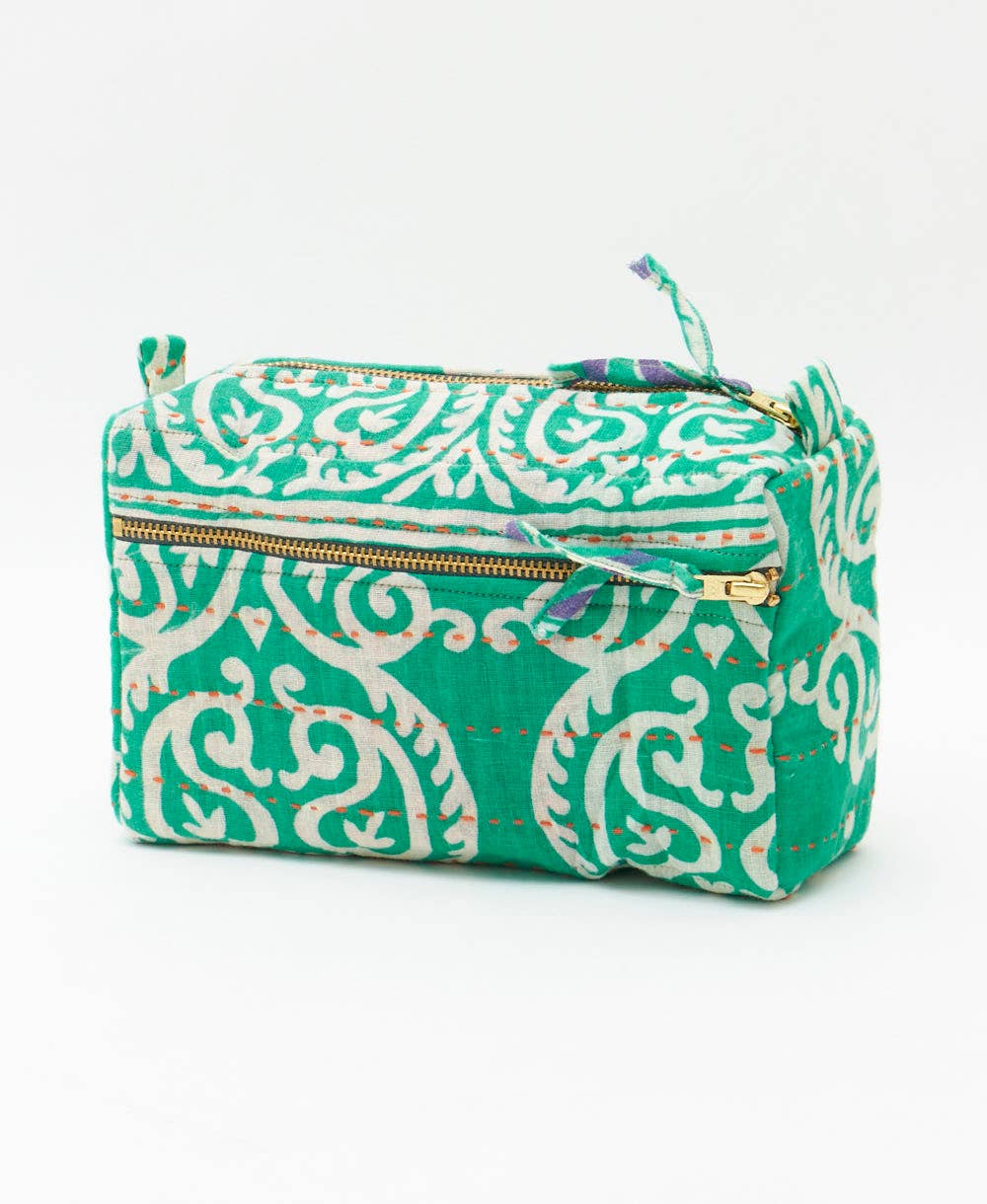 Green and white patterned pouch with a gold zipper on a white background