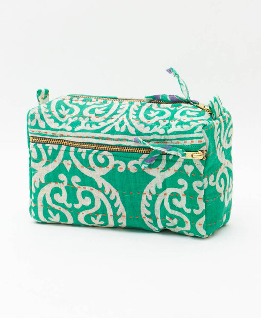 Green and white patterned pouch with a gold zipper on a white background