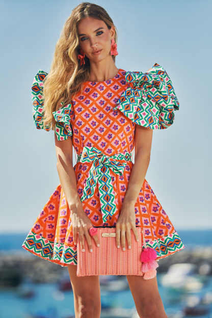 Woman wearing a colorful dress with a patterned background