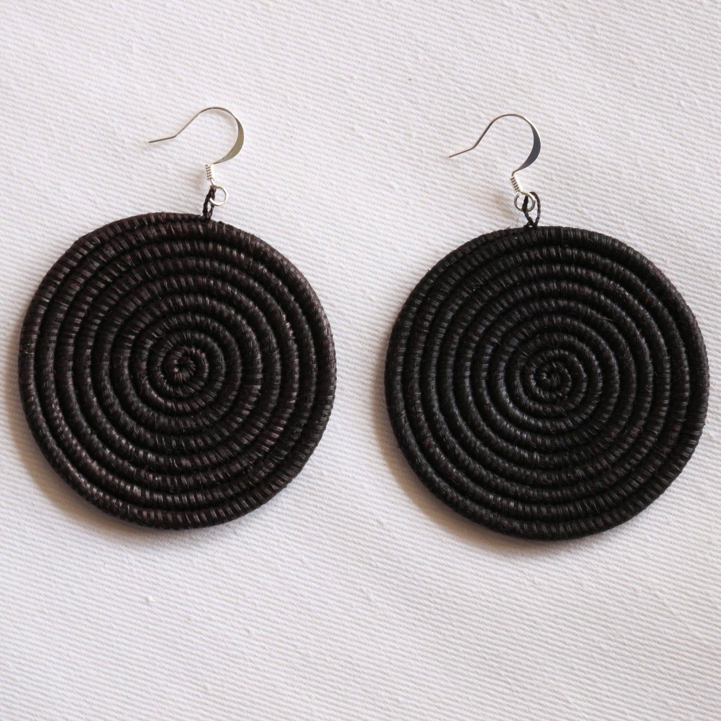 Black spiral earrings on a white background