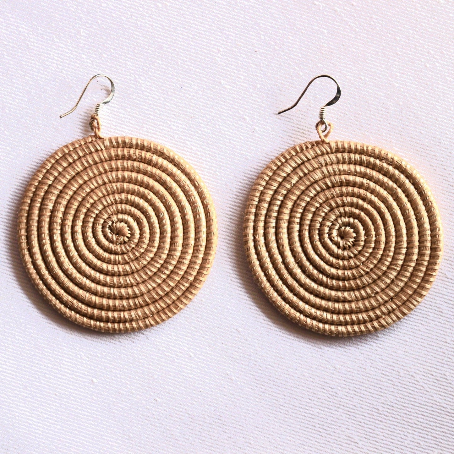 Pair of round, spiral-patterned earrings on a light background
