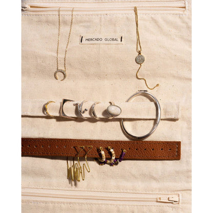 Jewelry set including necklaces, earrings, and a belt on a Mercado Global branded bag.