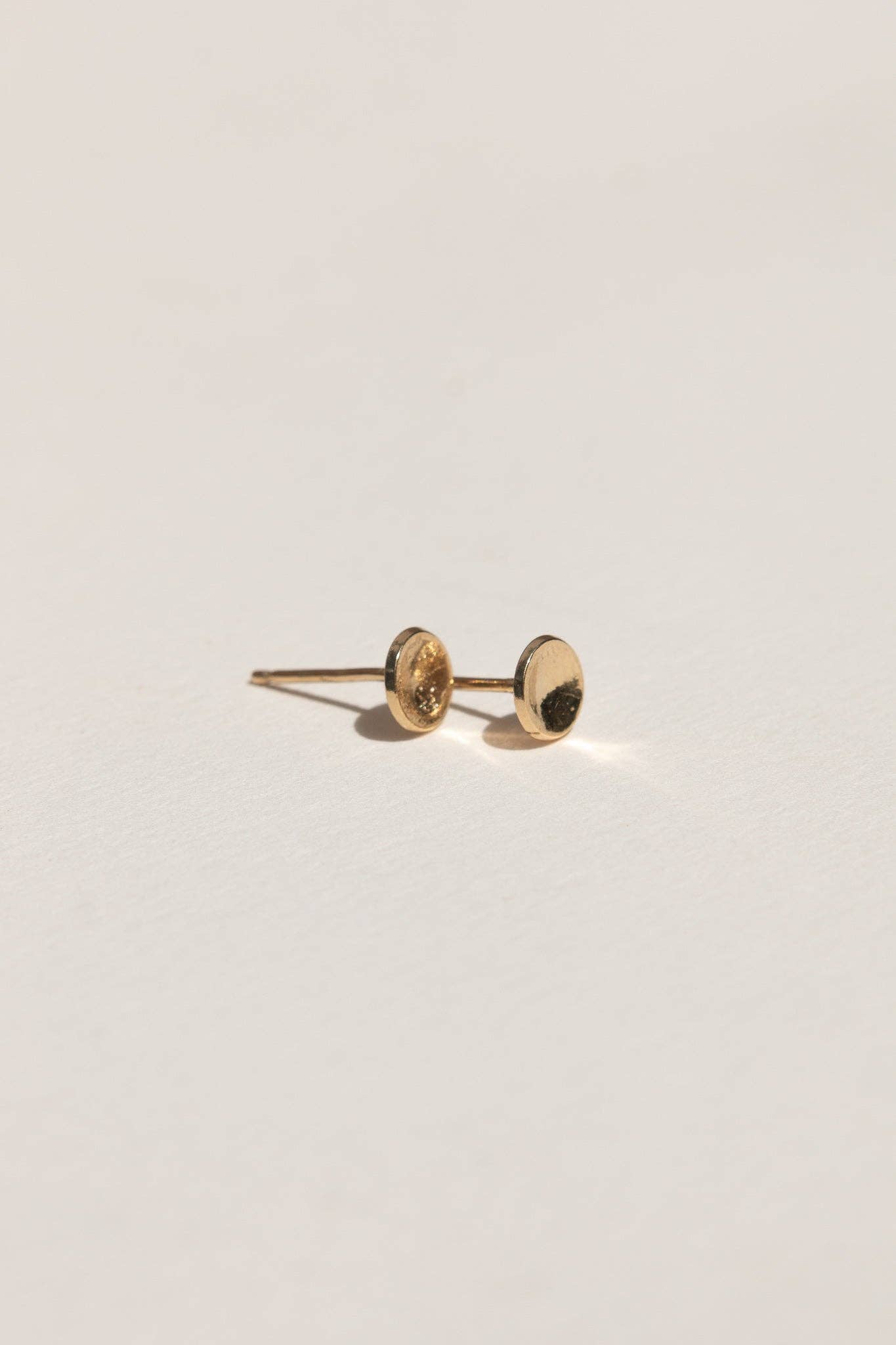 Gold earring on a light gray background