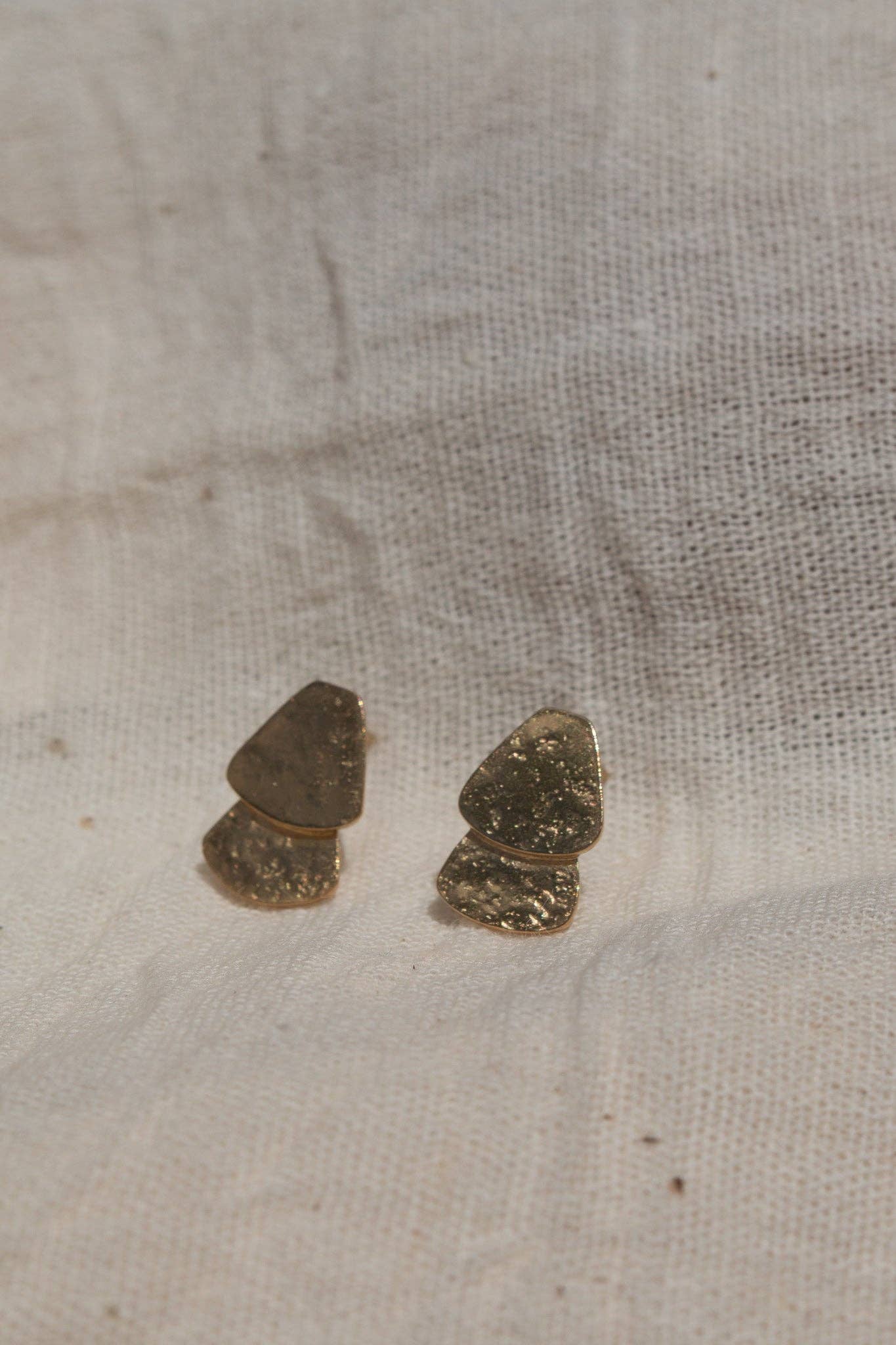 Two small stones on a textured beige fabric surface