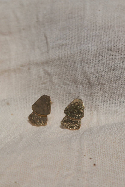 Two small stones on a textured beige fabric surface