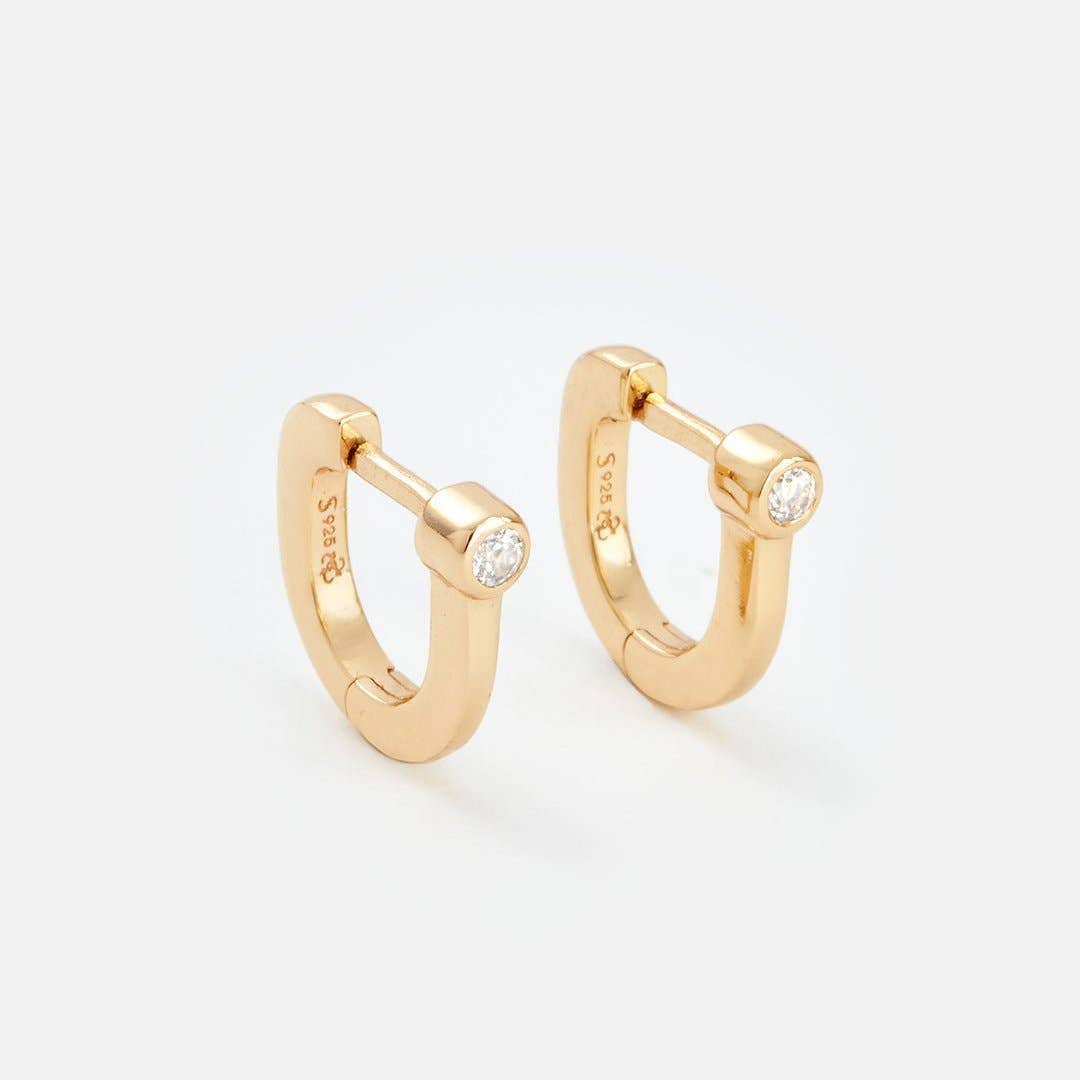 Gold hoop earrings with small diamonds on a light gray background