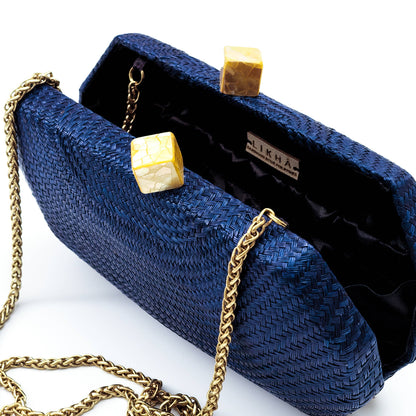 Blue clutch bag with gold chain and accents on a white background
