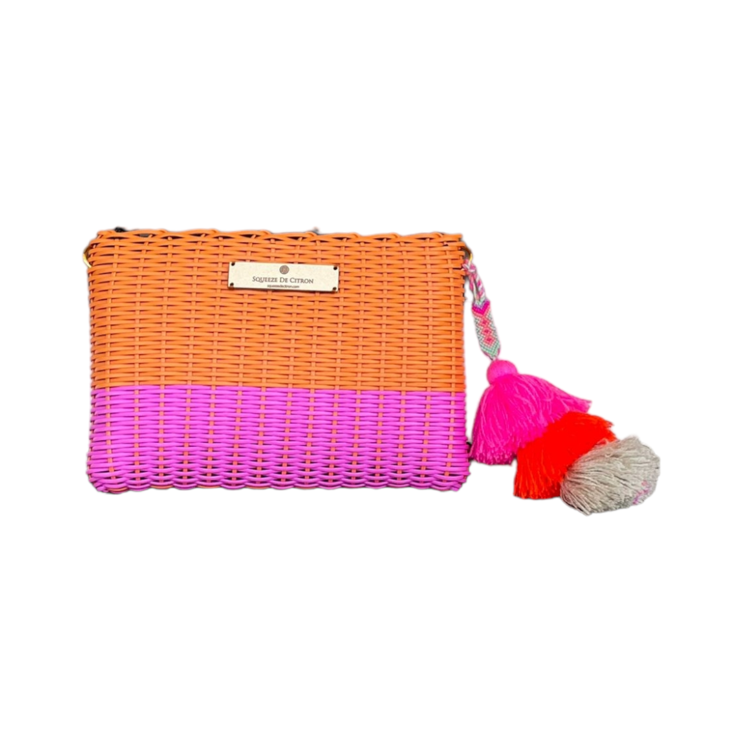 Woven clutch with pink bottom half and colorful tassel on a white background