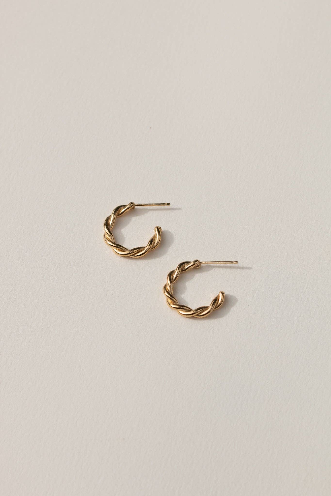 Gold hoop earrings on a light gray background