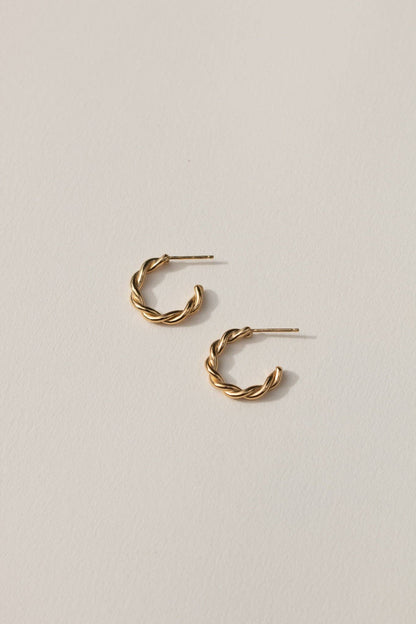 Gold hoop earrings on a light gray background