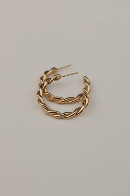 Gold hoop earrings on a light gray background