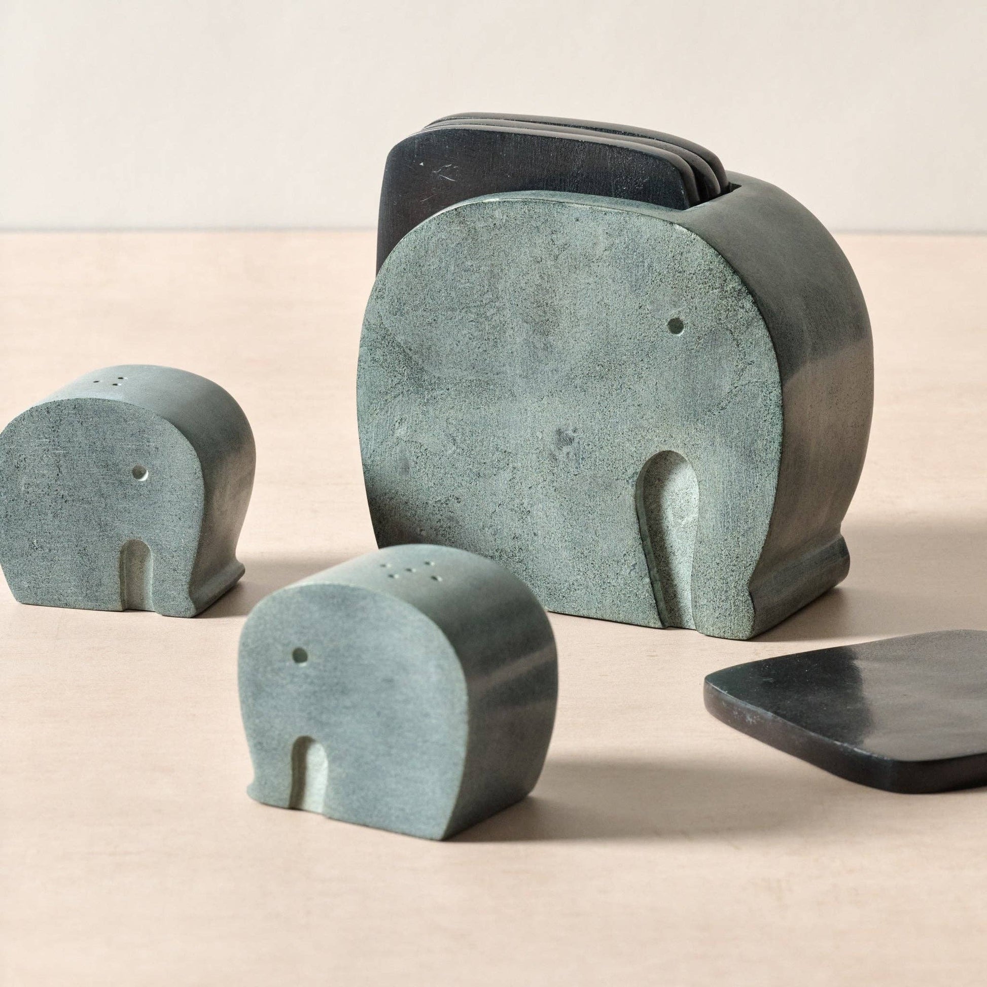 Set of stone elephant sculptures on a beige background
