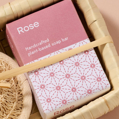Handcrafted plant-based soap bar with pink packaging in a woven basket