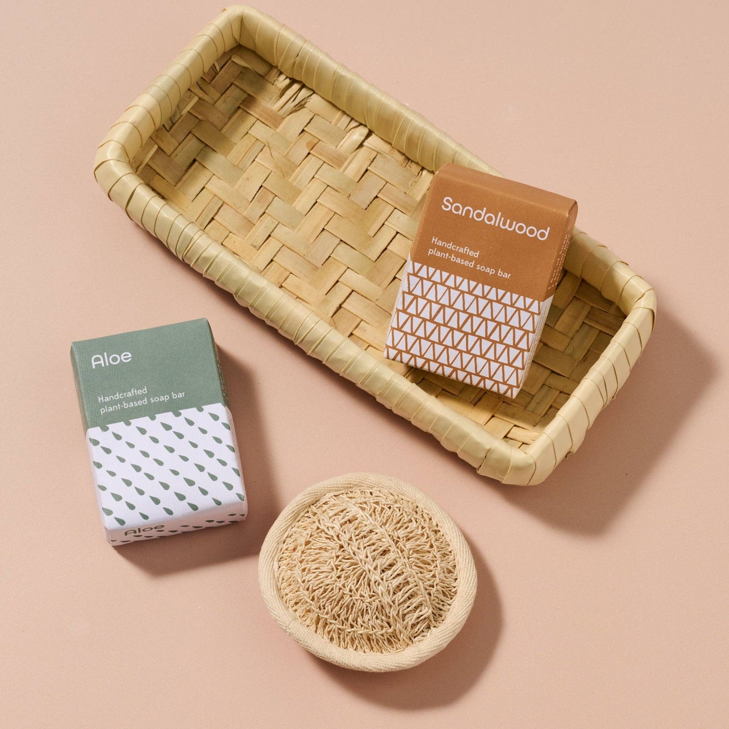Handcrafted soap bars with packaging and a natural sponge on a beige background