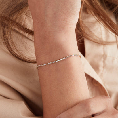 Close-up of a person's wrist wearing a delicate silver bracelet.