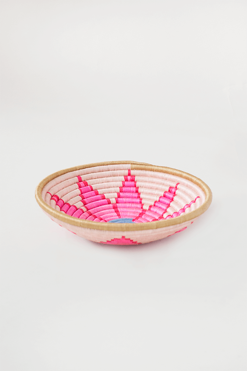 Woven basket with pink and red pattern on a white background