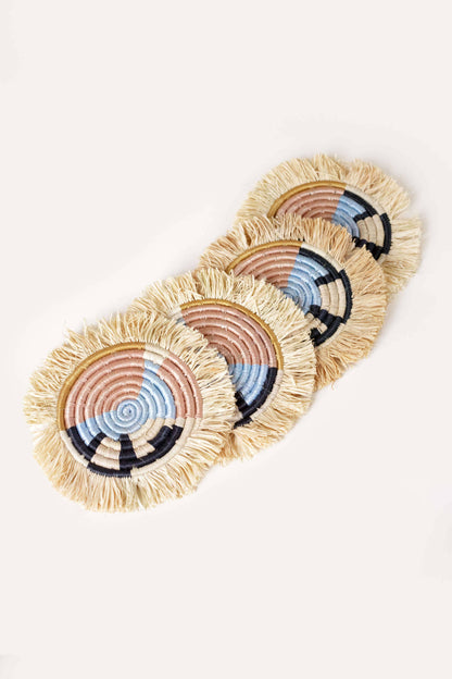 Set of four woven coasters with colorful patterns on a light background