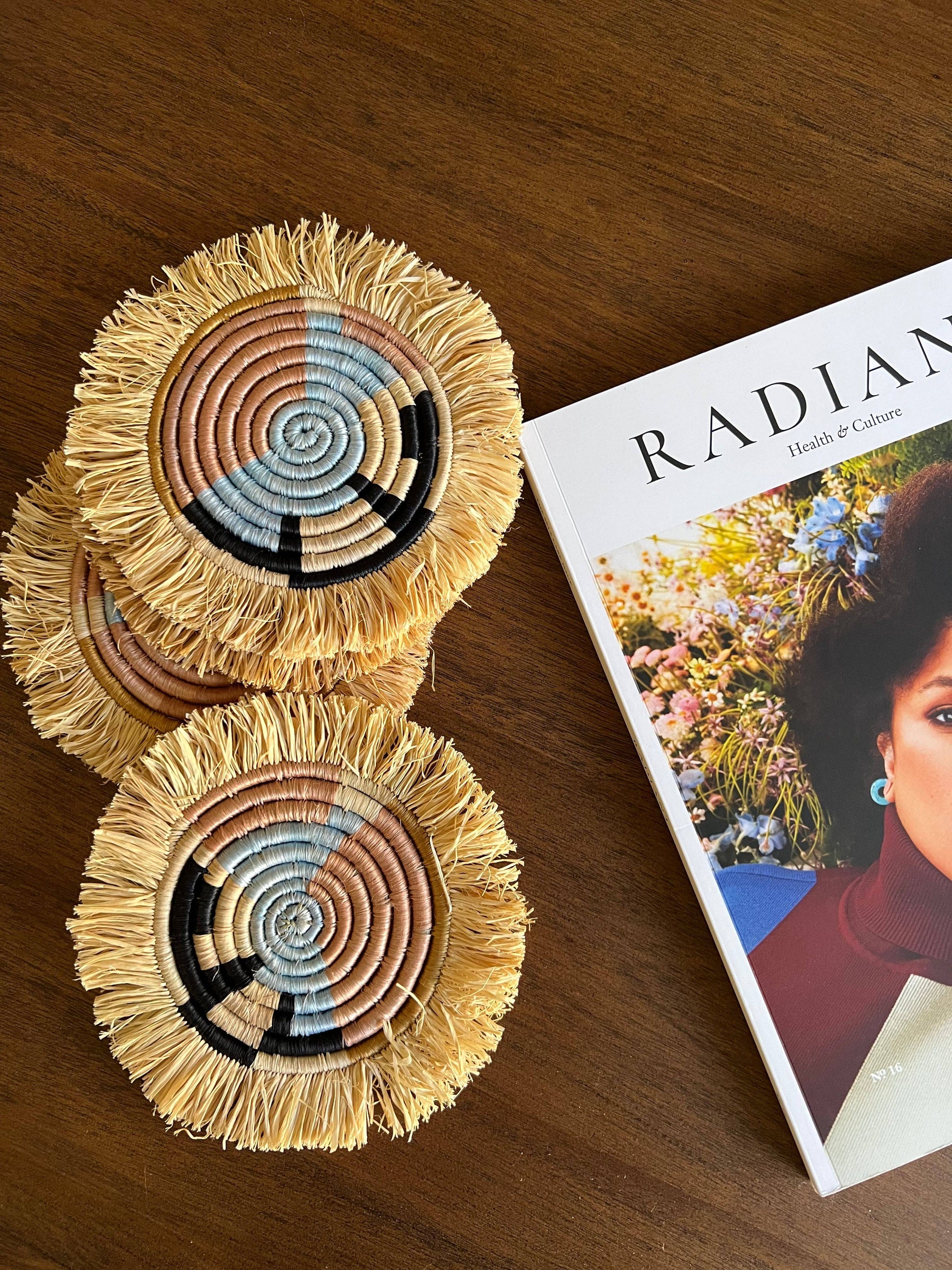 Two woven coasters on a wooden surface next to a magazine titled 'Radian'.