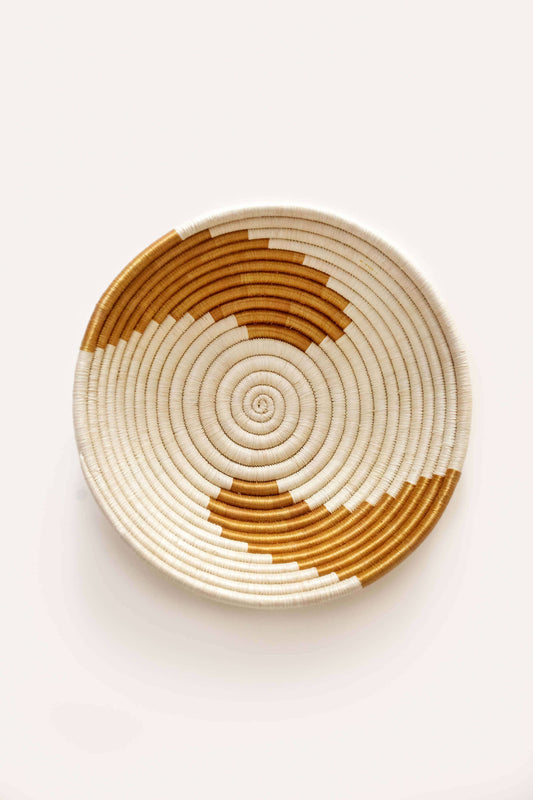 Woven basket with concentric circle pattern on a white background