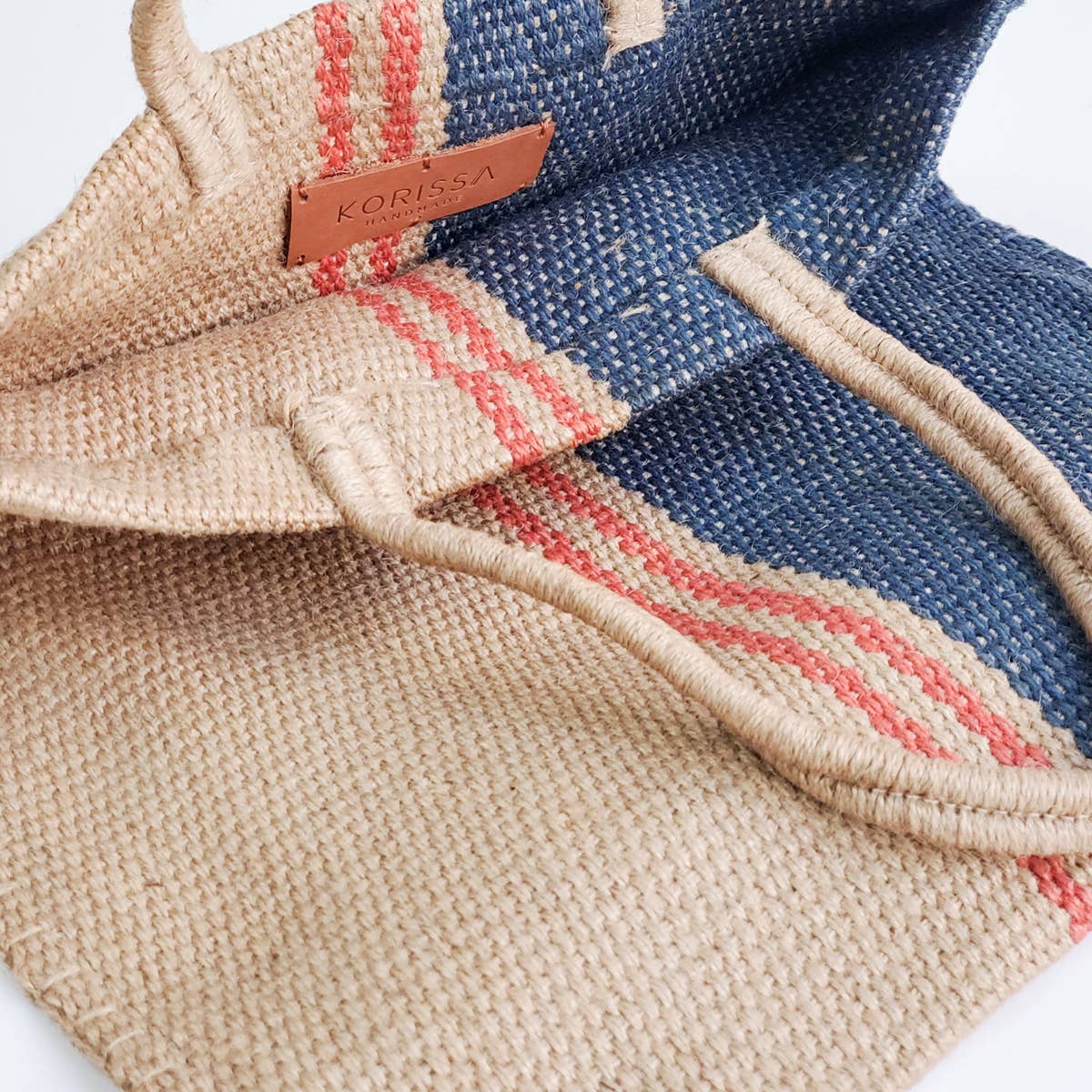 Textured fabric bag with a visible brand label on a white background