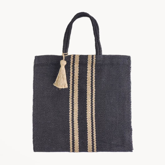 Black woven tote bag with beige stripes and a tassel on a white background