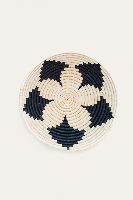 Woven basket with black and beige pattern on a white background