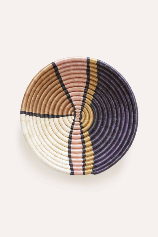 Woven basket with concentric circle pattern on a white background