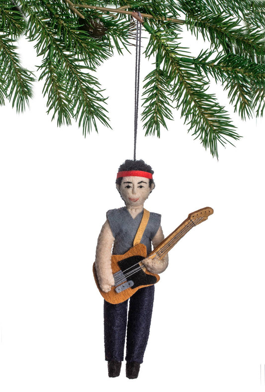 Ornament of a person playing guitar hanging from a tree branch