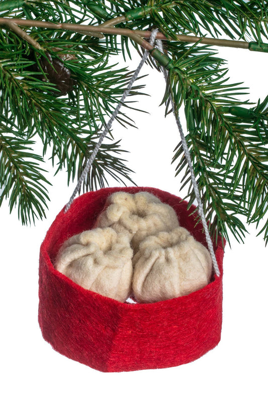 Red felt basket with beige dim sum hanging from a Christmas tree branch.
