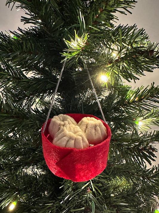 Red felt basket with beige dim sum hanging on a Christmas tree.