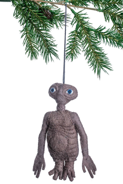 Brown alien ornament hanging from a pine branch