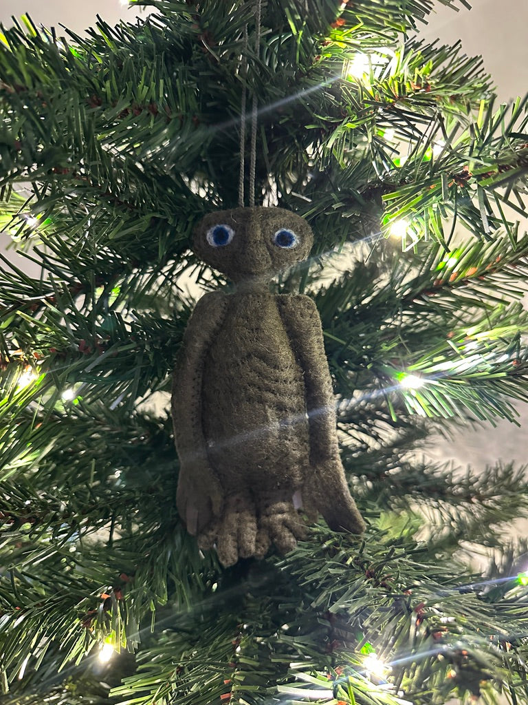 Brown extra terrestrial ornament hanging on a Christmas tree