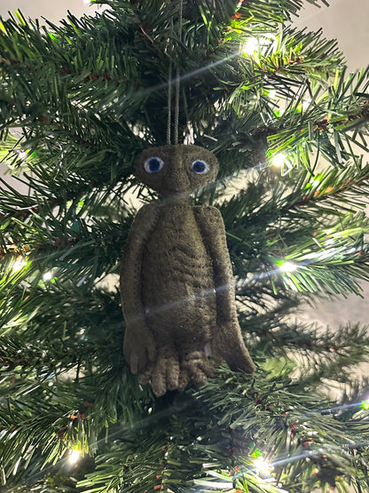 Brown extra terrestrial ornament hanging on a Christmas tree