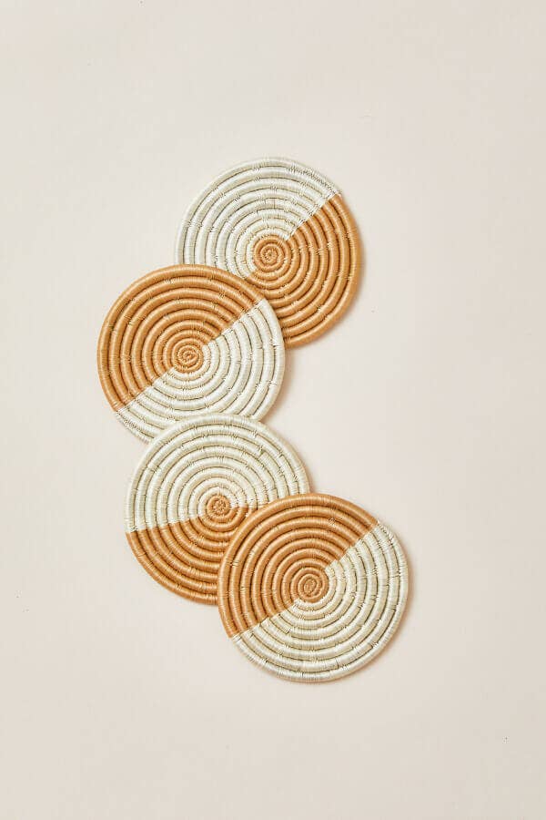 Set of four woven coasters with concentric circle pattern on a beige background