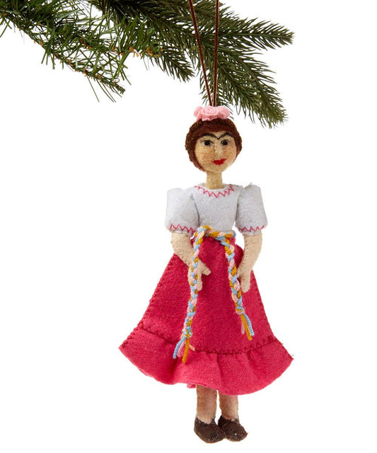 Decorative doll ornament with a pink skirt and white top hanging from a Christmas tree branch.